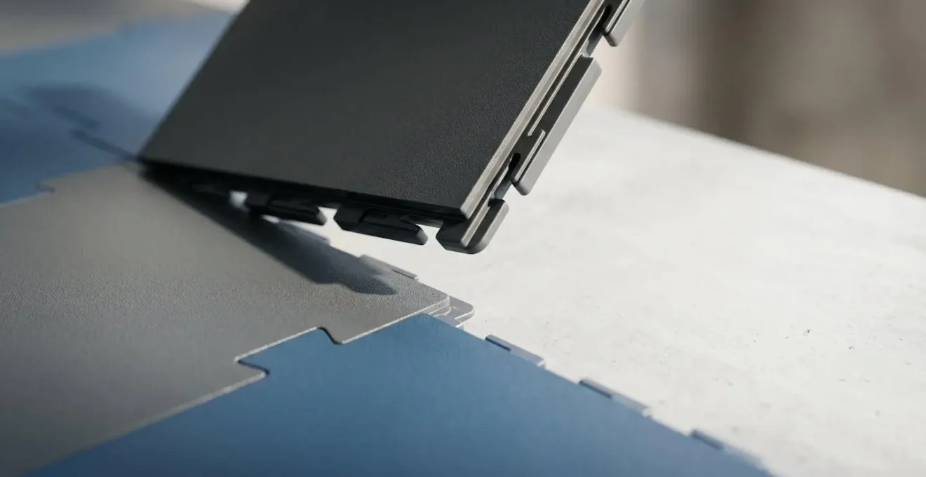 Vue en perspective d'un système de dalles PVC clipsables montrant le mécanisme d'emboîtement et la réversibilité du revêtement