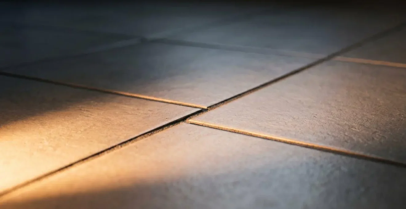 Défaut subtil d'alignement de joints de carrelage révélé par une lumière rasante