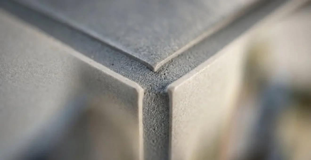 Détail macro d'un joint époxy entre carreaux industriels montrant la structure résistante aux produits chimiques