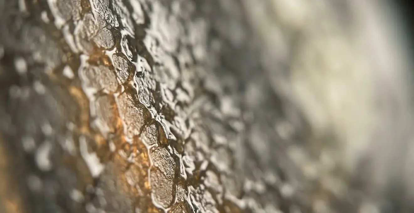 Gros plan macro sur la texture d'une résine époxy révélant sa structure réticulée